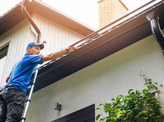 Profissional instalando calha em residência